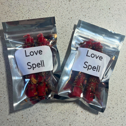 Two packages labeled 'Love Spell' on a speckled countertop.