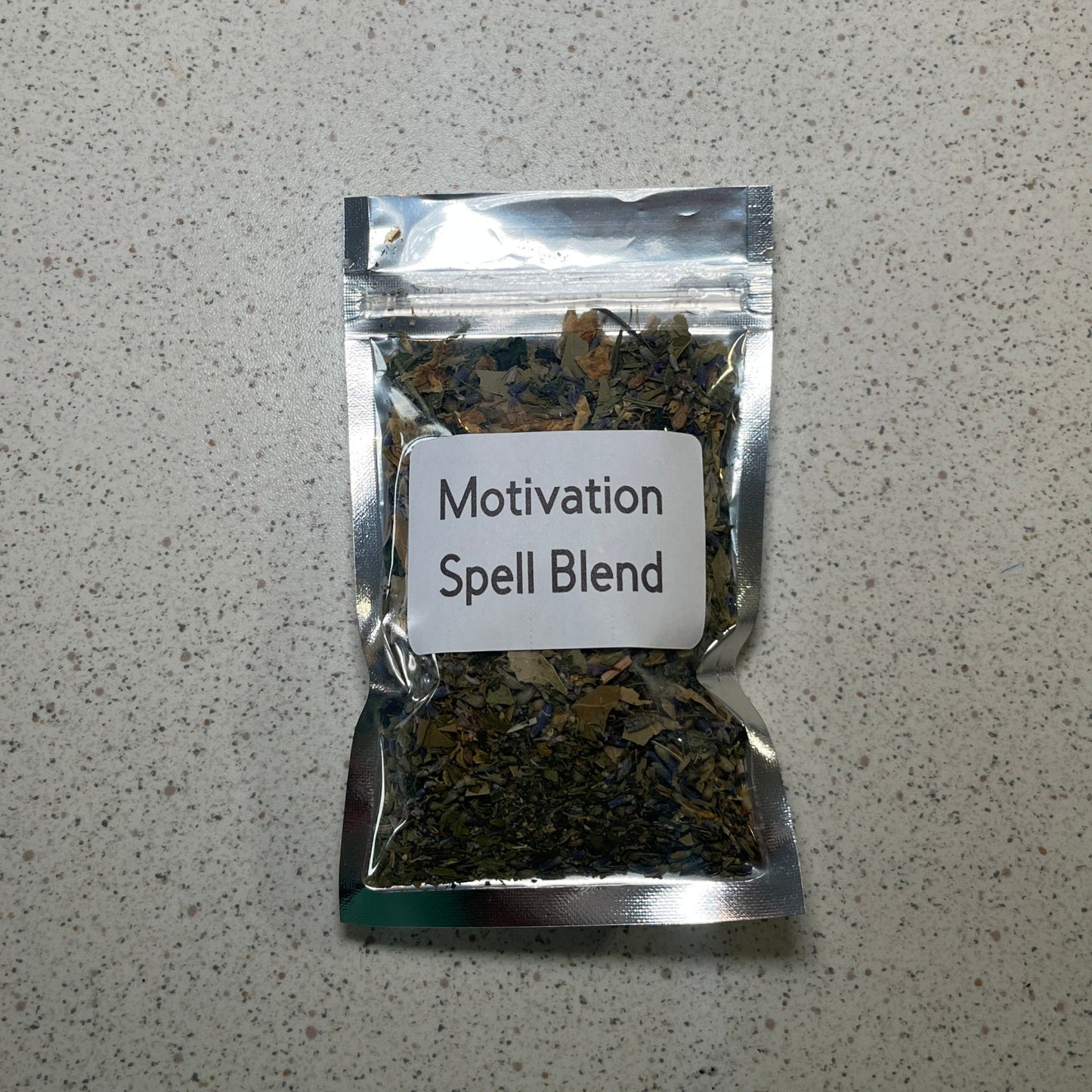 Packaged 'Motivation Spell Blend' on a gray surface