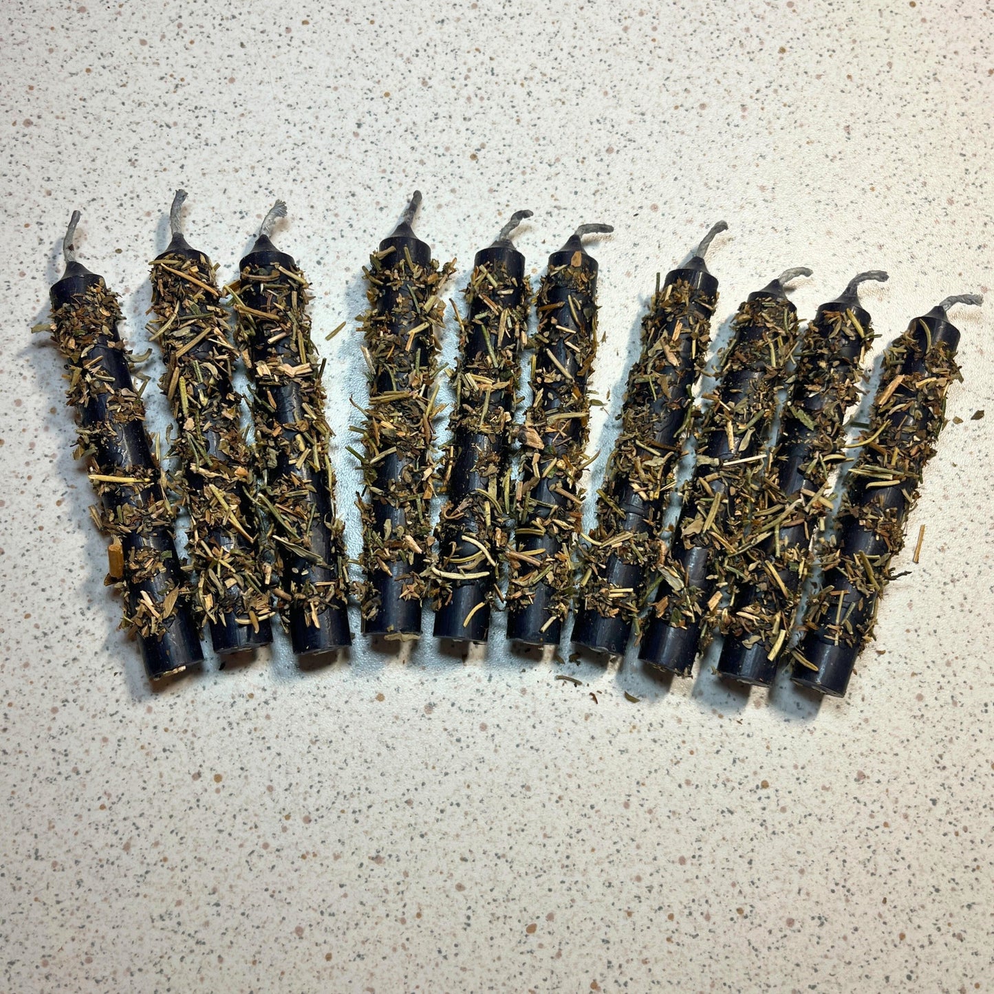 black chime candles dressed with herbs