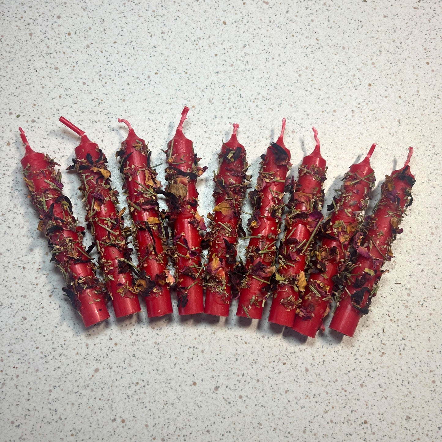 Red candles dressed with herbs