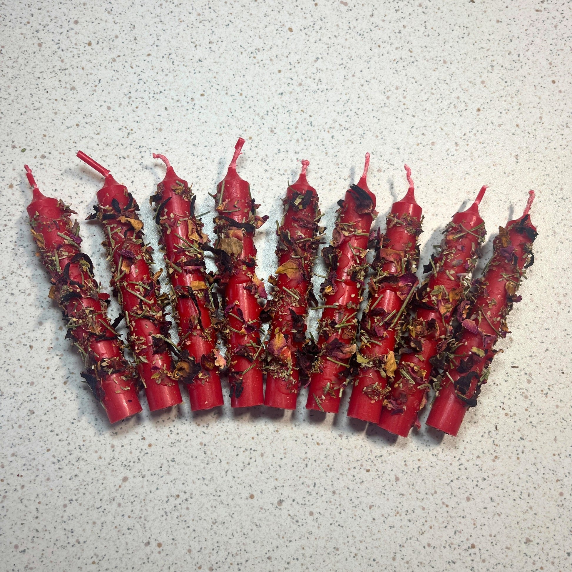 Red candles dressed with herbs