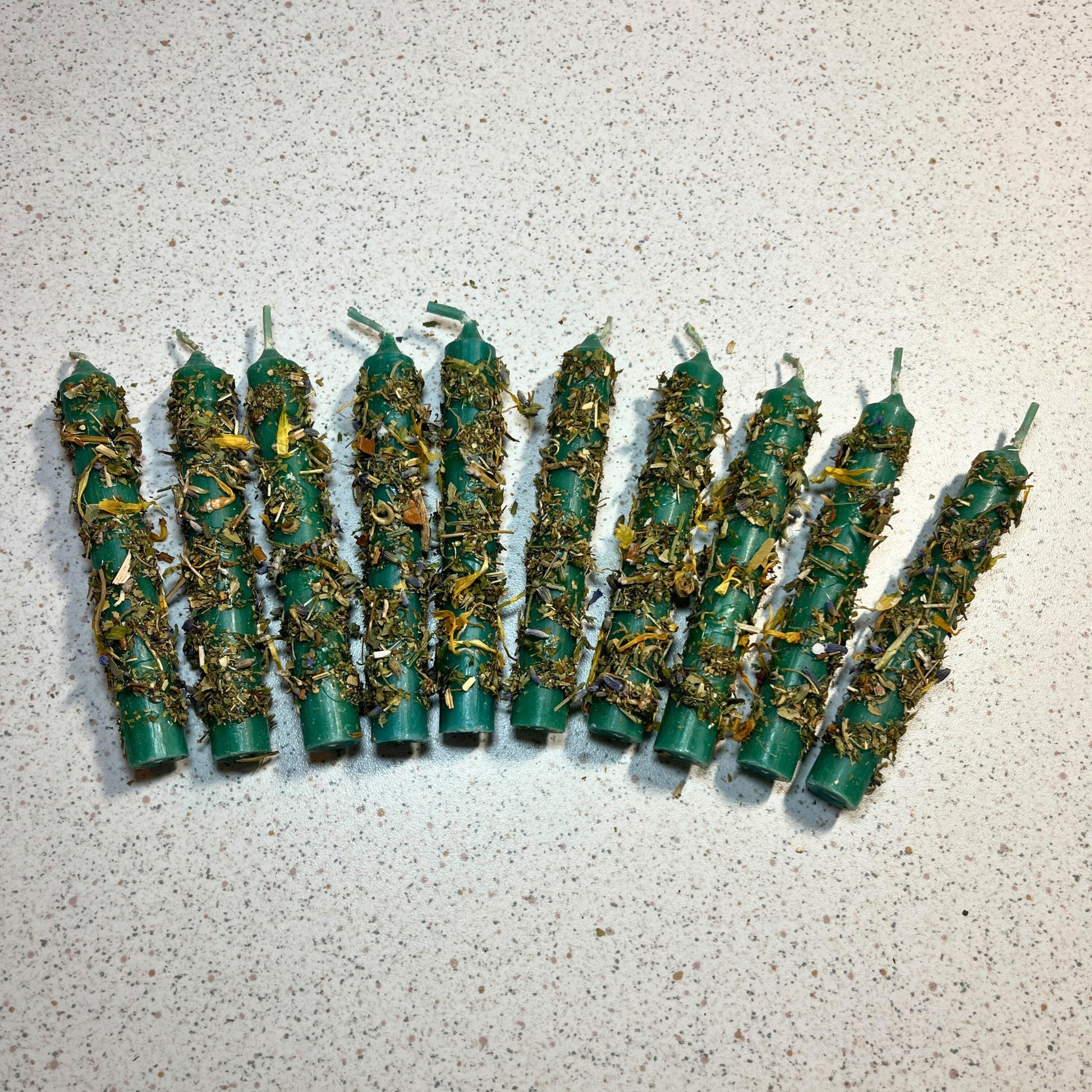 Green ritual candles dressed with herbs