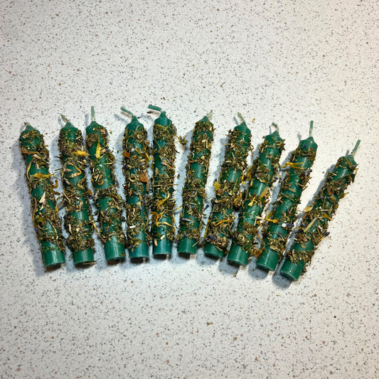 Green ritual candles dressed with herbs