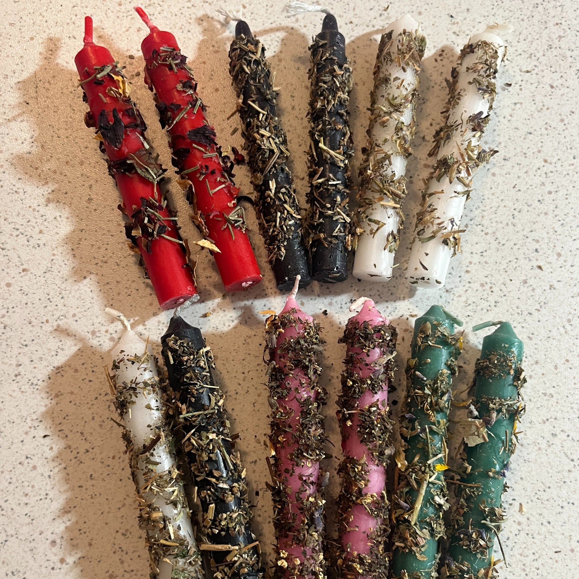 Assorted candles dressed in herbs