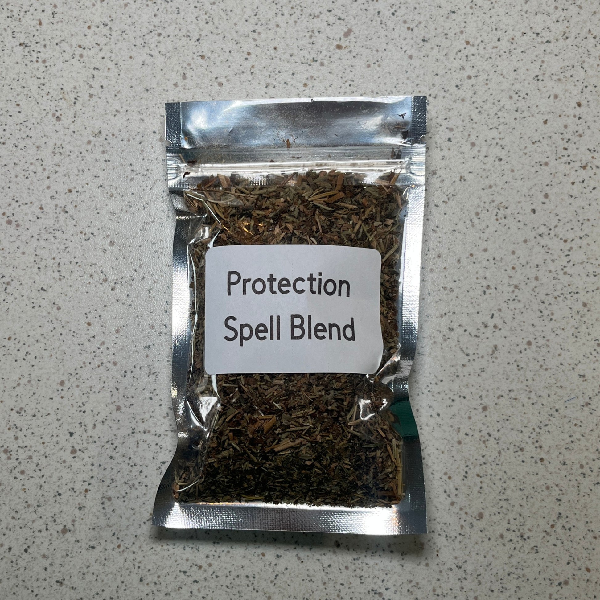 Packaged protection spell blend on a gray surface